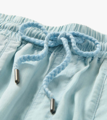Close-up of light blue drawstring waistband on straight-leg pants with metal aglets