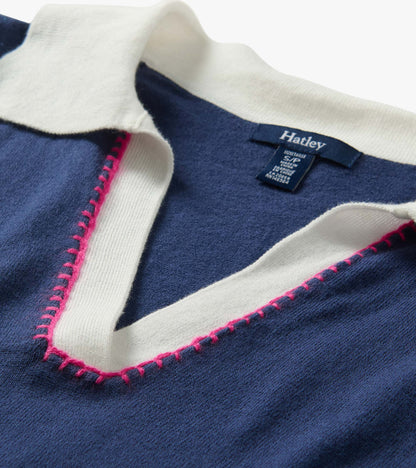 Close-up of a navy knit collared top with white trim and pink contrast stitching, folded neckline detail