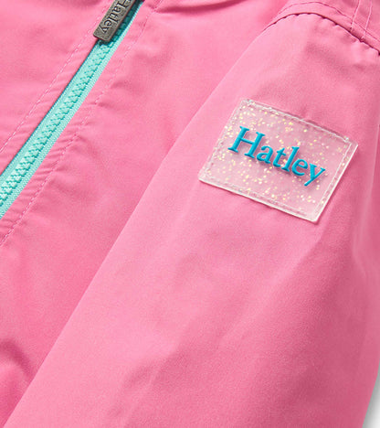 Pink girls rain jacket with turquoise zipper and clear glittery chest patch