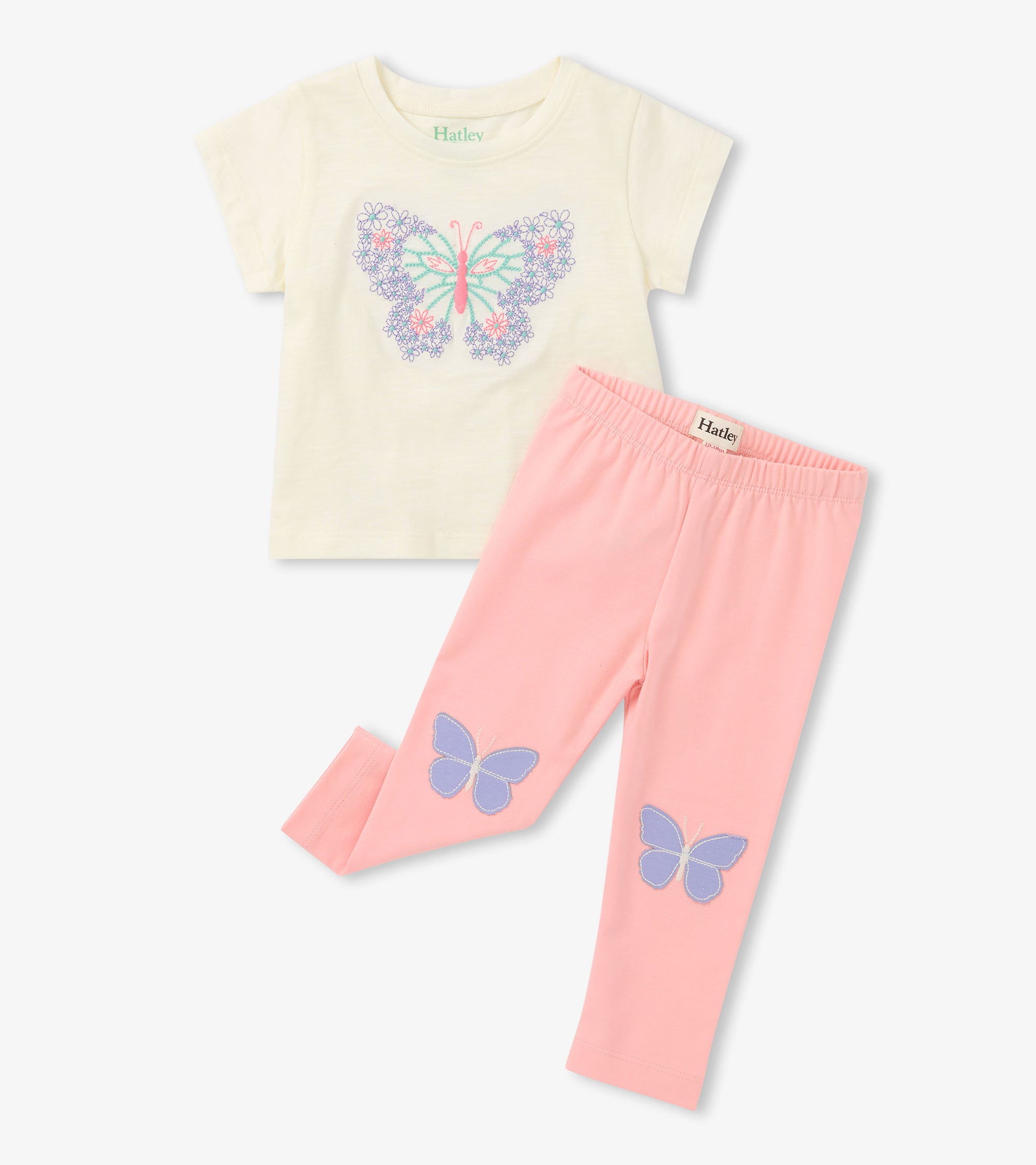 Cream short-sleeve T-shirt with butterfly print and pink leggings with butterfly patches, laid flat