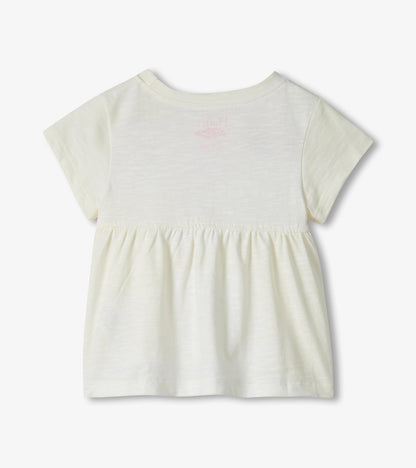 Cream short-sleeve toddler dress with gathered waist and faint pink flamingo print on back, back view