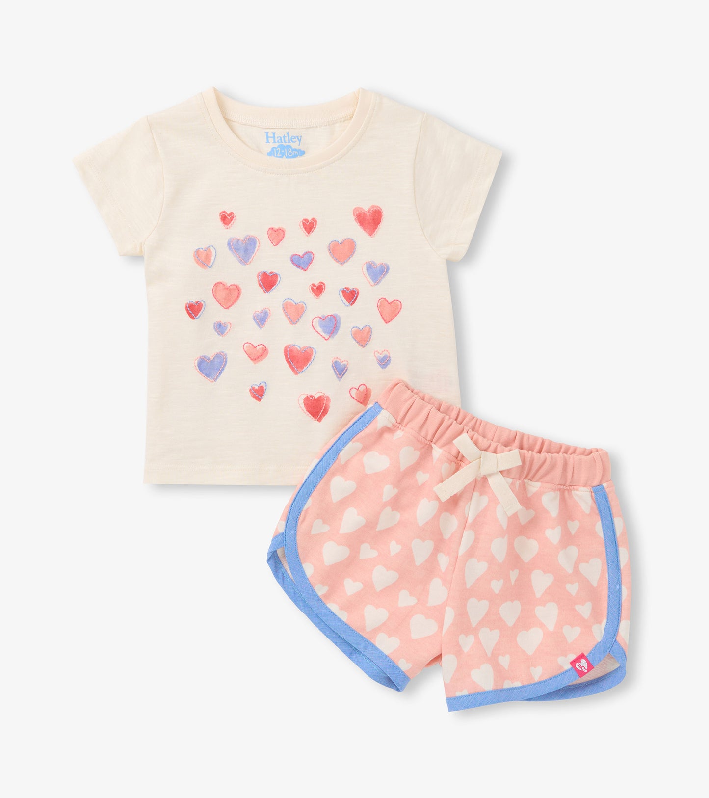 Cream short-sleeve T-shirt with multicolor heart print and pink heart-print shorts with blue trim, front view