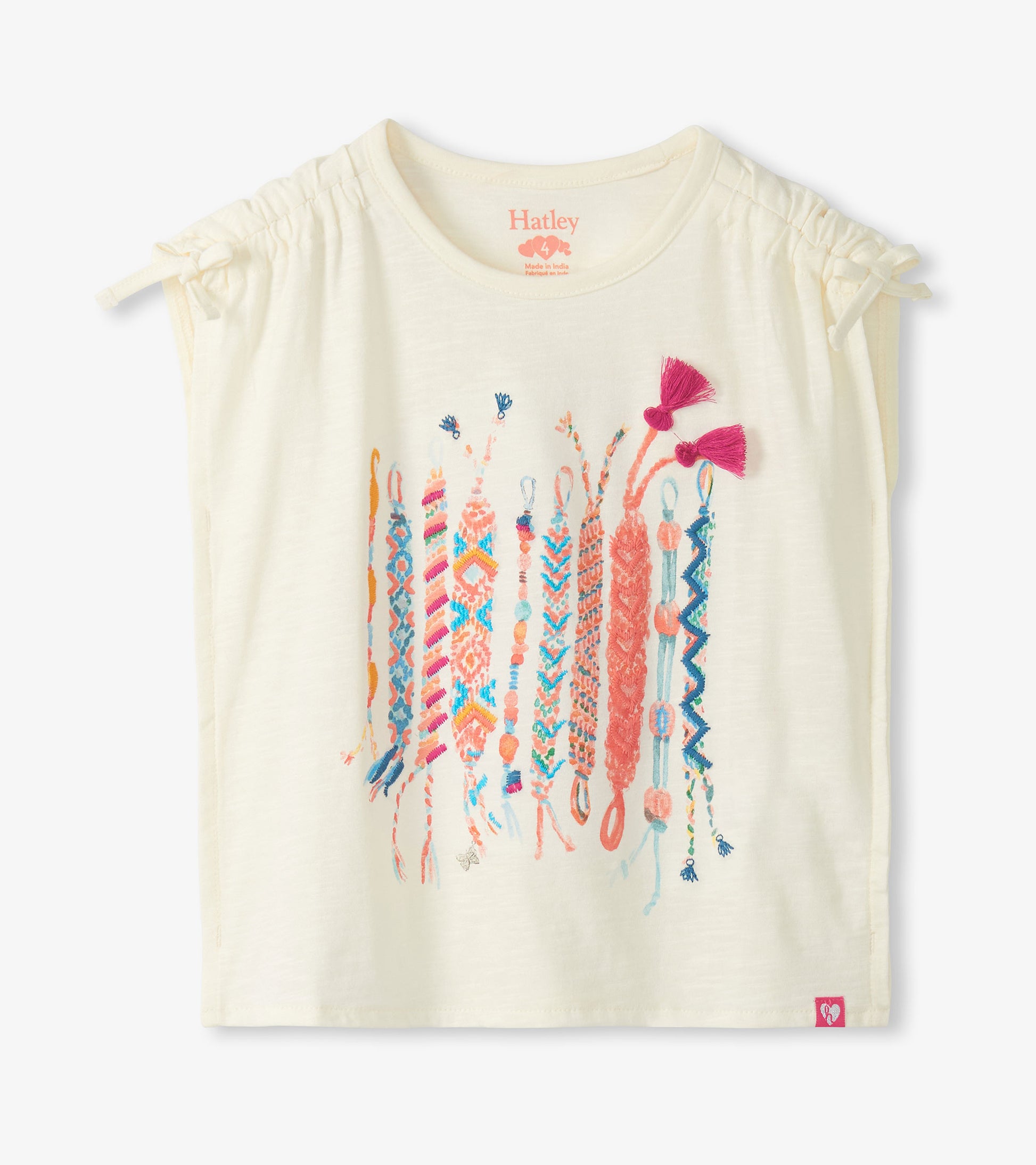 Cream short-sleeve girls top with cinched shoulders and colorful friendship bracelet graphic on the front