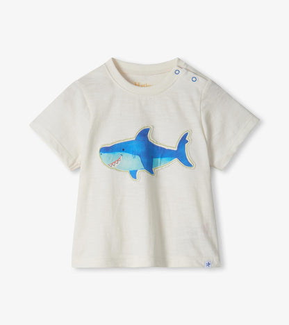 Cream short-sleeve toddler T-shirt with blue shark graphic and shoulder snaps, front view