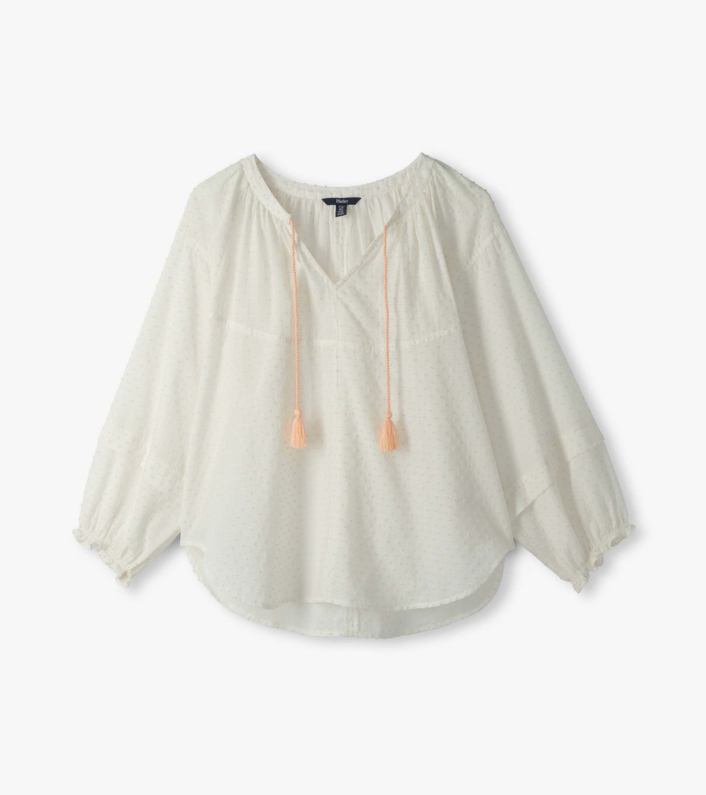 Blush Swiss dot blouse with V-neck, tassel ties, and long puff sleeves, front view