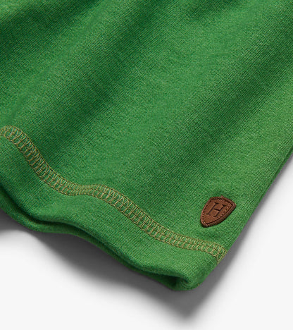 Close-up of green knit shorts hem with stitched seam and small brown patch logo
