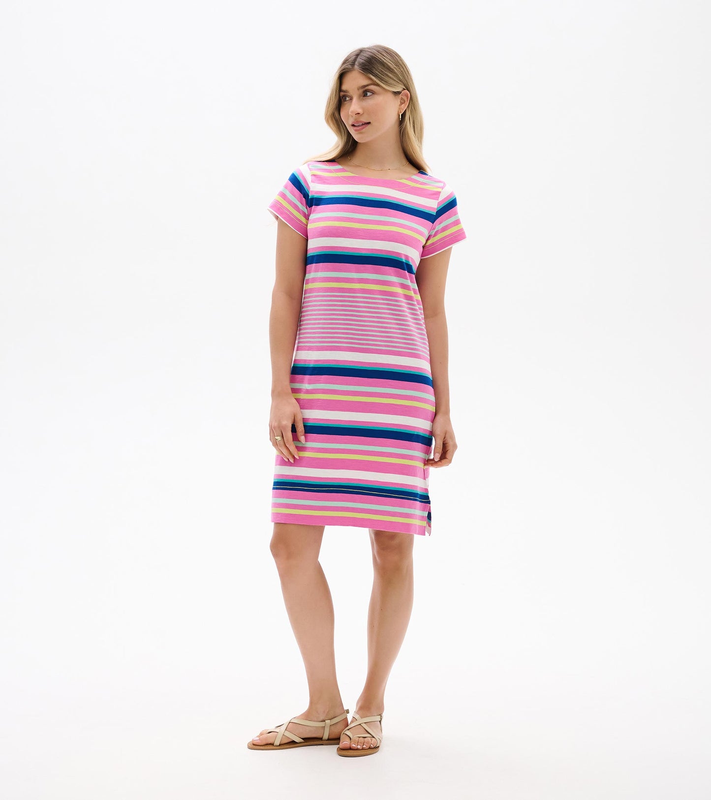 Woman wearing a short-sleeve pink striped tee dress with multicolor horizontal stripes and side slit, front view.