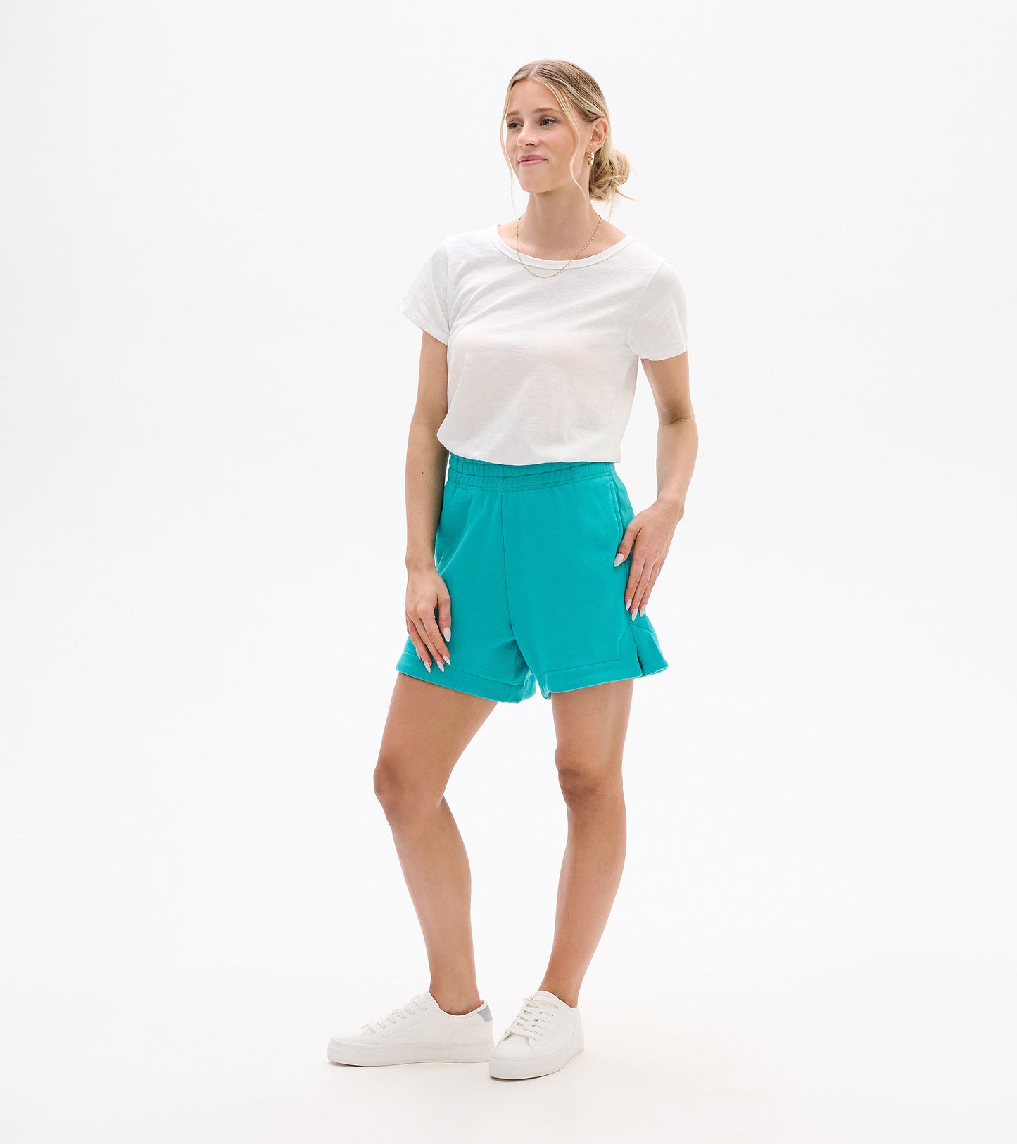 Turquoise high-waisted shorts with elastic waistband and cuffed hems, shown on a model front view.