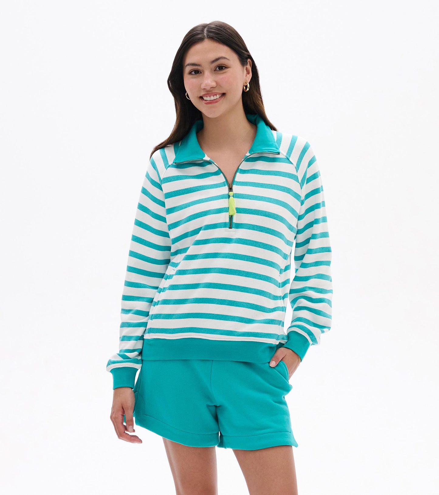 Front view of a green and white striped mock neck pullover with quarter-zip and long sleeves, worn with teal shorts.