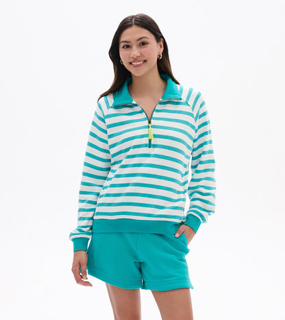 Front view of a green and white striped mock neck pullover with quarter-zip and long sleeves, worn with teal shorts.