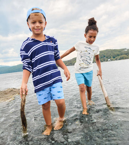 Boy wearing navy striped hooded long-sleeve cover-up with light blue shorts, front view, standing in water