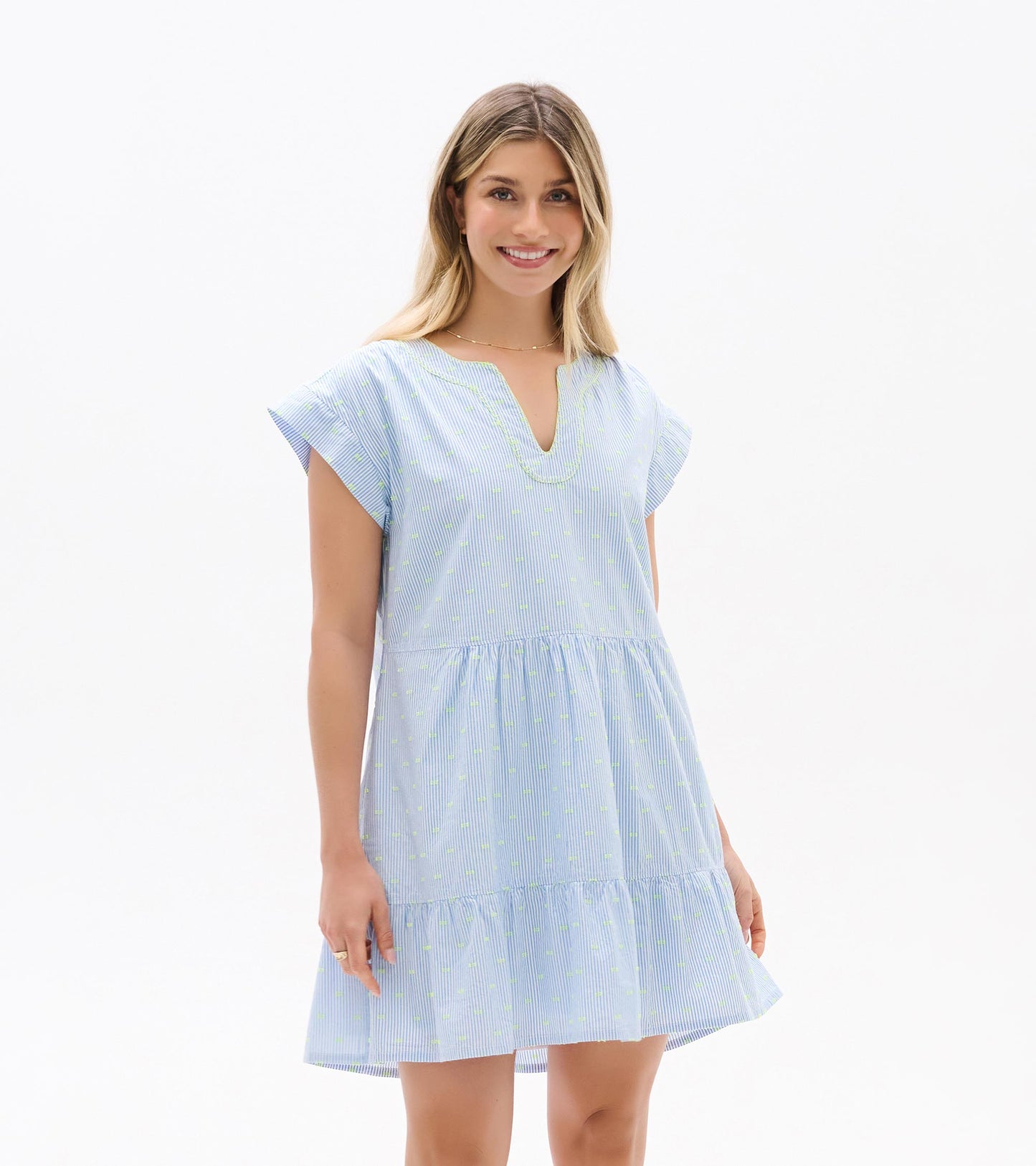 Front view of blue and white striped dress with neon dots, split neckline, cap sleeves, and tiered hem