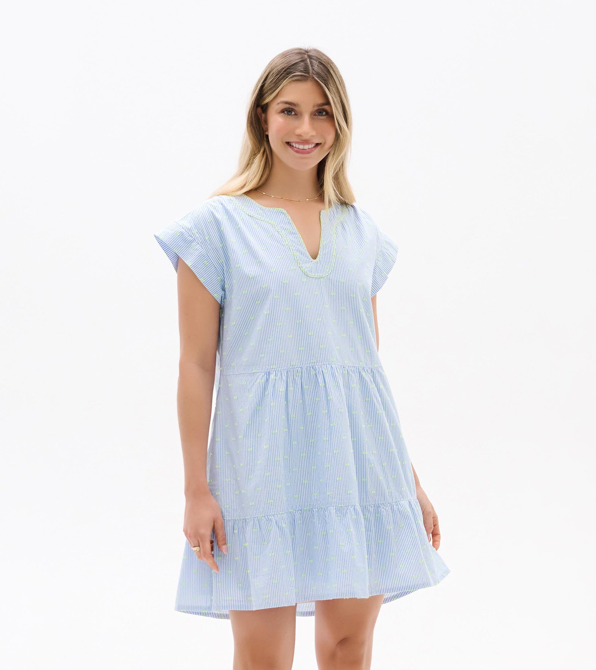 Front view of blue and white striped dress with neon dots, split neckline, cap sleeves, and tiered hem