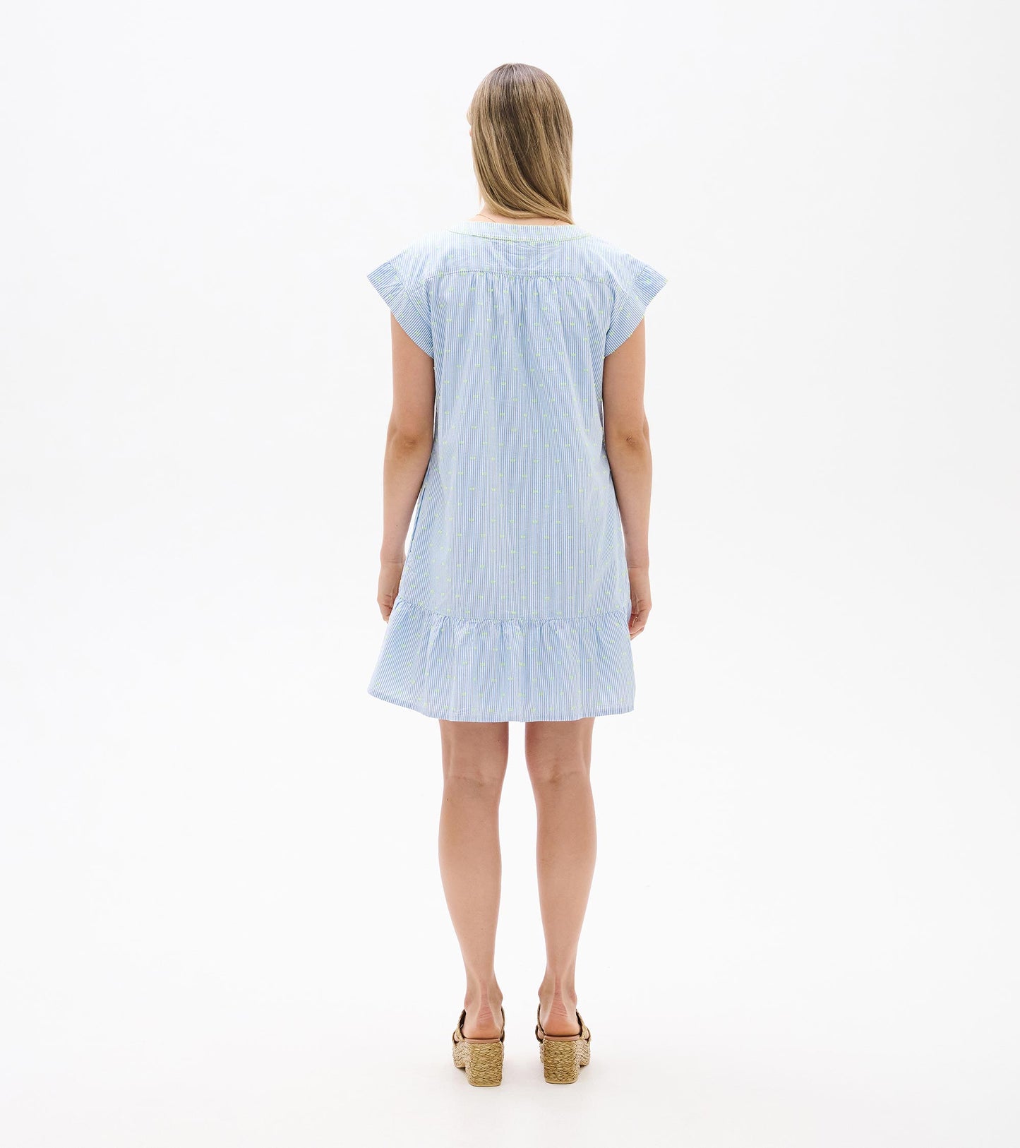 Back view of blue and white striped dress with neon dots, cap sleeves, and gathered tiered hem