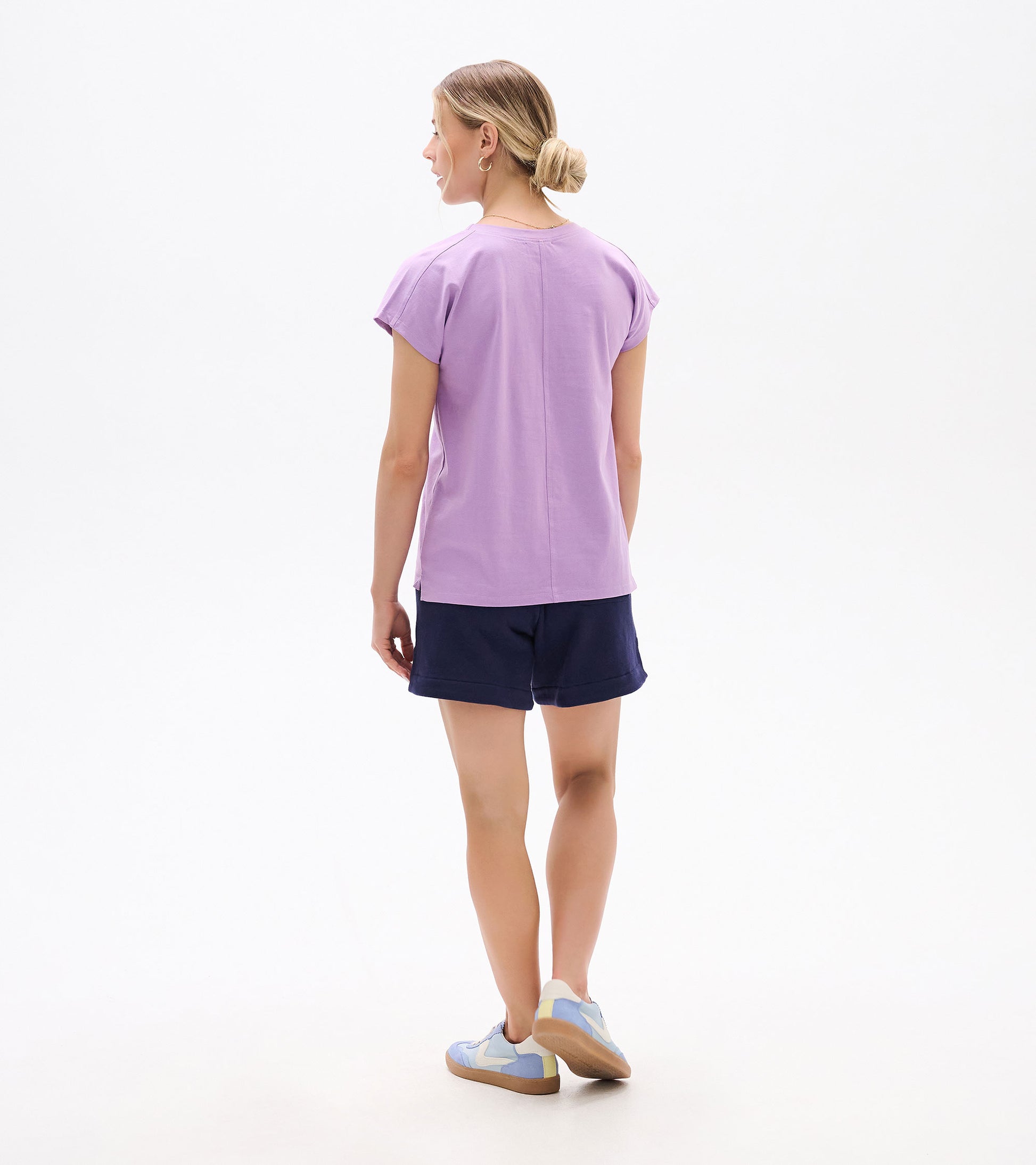 Back view of a relaxed lavender short-sleeve tee with a crew neck and straight hem, worn with navy shorts.