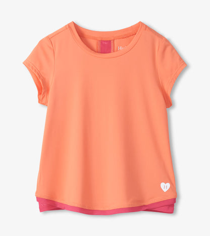 Coral short-sleeve girls' T-shirt with round neck and pink mesh trim peeking at hem and neckline, front view