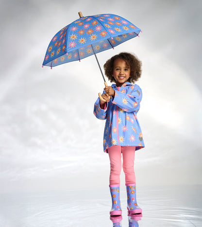Blue umbrella with pink and yellow sun pattern, shown open and held by a child