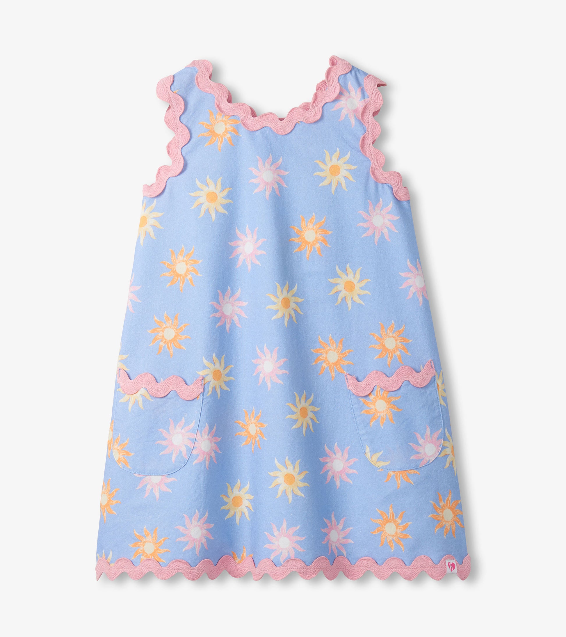 Light blue girls pinafore dress with pastel sun print, pink scalloped trim, and front patch pockets