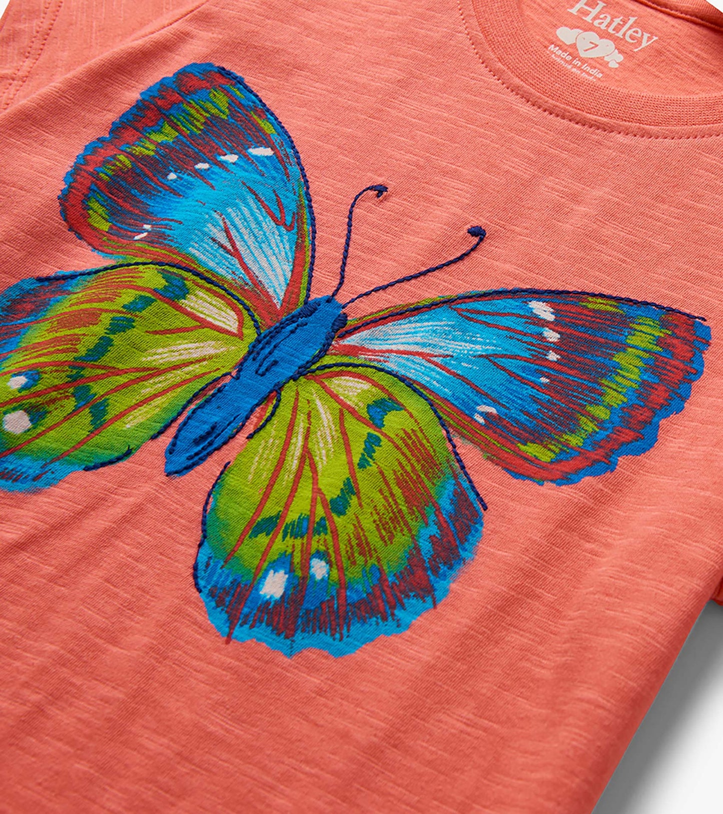 Coral girls T-shirt with large colorful butterfly graphic and tie-front detail, close-up front view