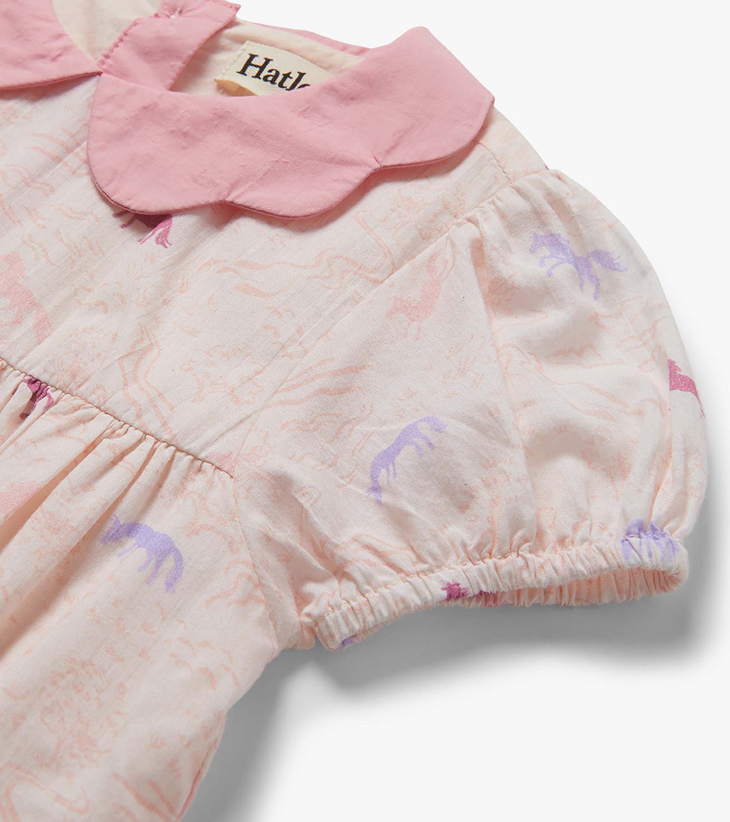 Pink woven toddler dress with scalloped collar and pastel pony print, close-up front view