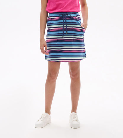 Woman wearing a striped blue, pink, and white drawstring skirt with side pockets, front view