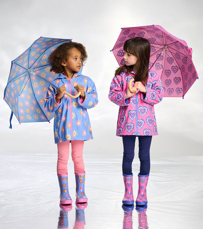 Girls wearing blue and pink heart-print rain boots with matching raincoats and umbrellas