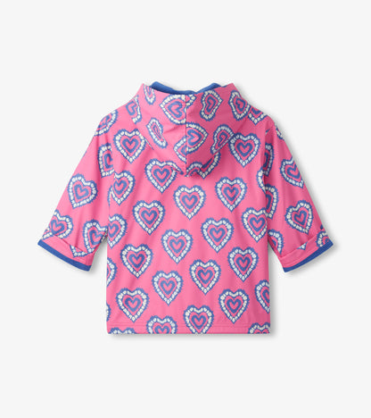 Pink hooded zip-up rain jacket with blue heart pattern, back view