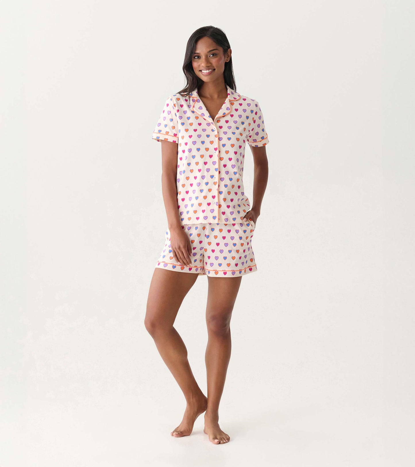 Women’s short-sleeve pajama set with button-front top and shorts, cream with multicolor heart print, front view