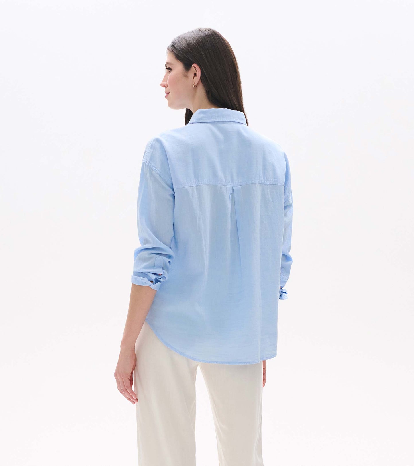 Light blue chambray button-down shirt shown from the back, with rolled sleeves and a relaxed fit.