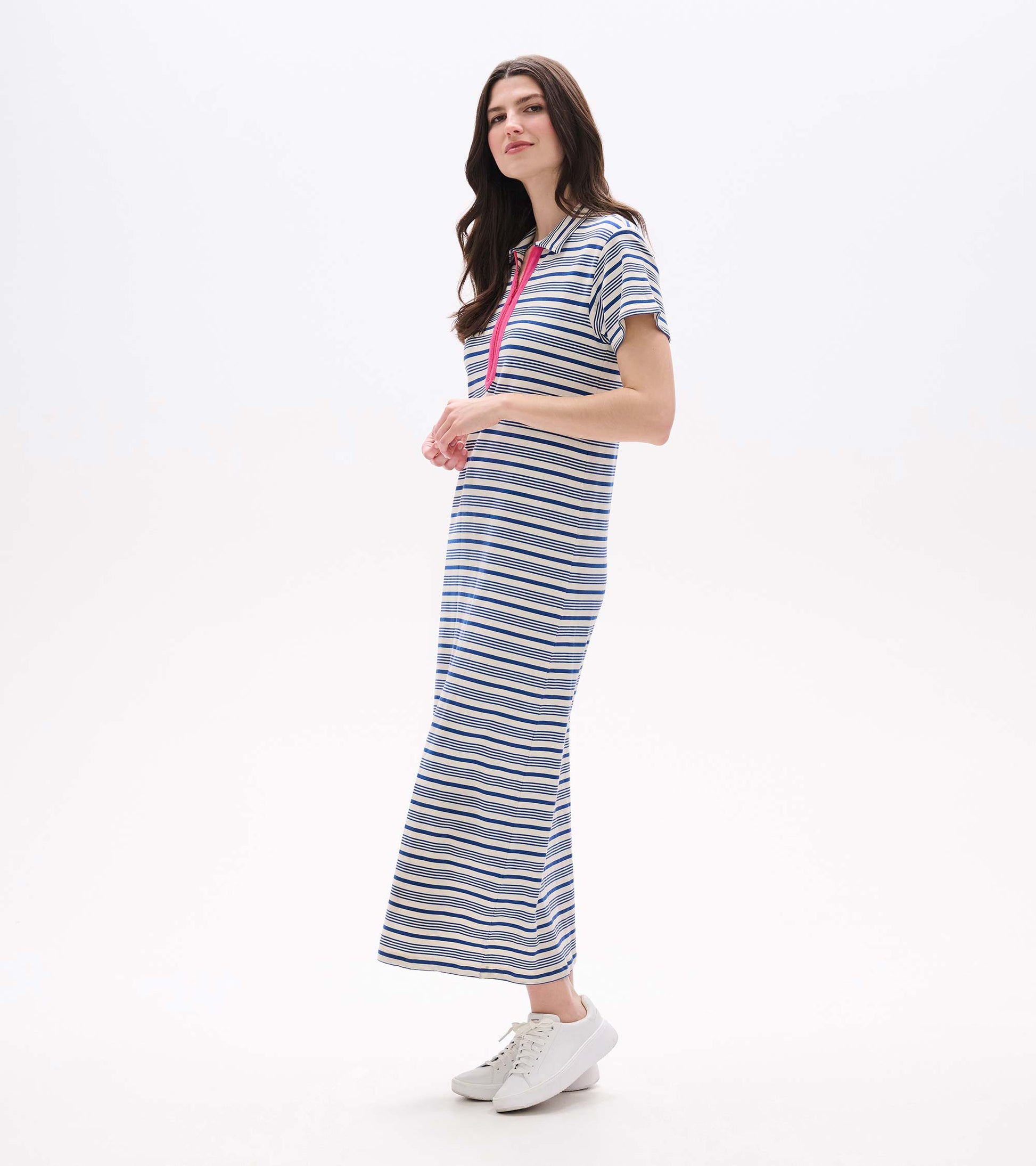 Woman wearing a blue-and-white striped maxi dress with pink zip detail and short sleeves, front view.