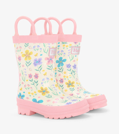 Pink toddler rain boots with floral and chick print, side view, white and pastel pattern, pink soles and handles