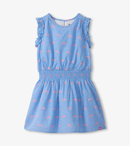 Blue girls woven dress with pink dolphin print, ruffled sleeves, and smocked waist, front view