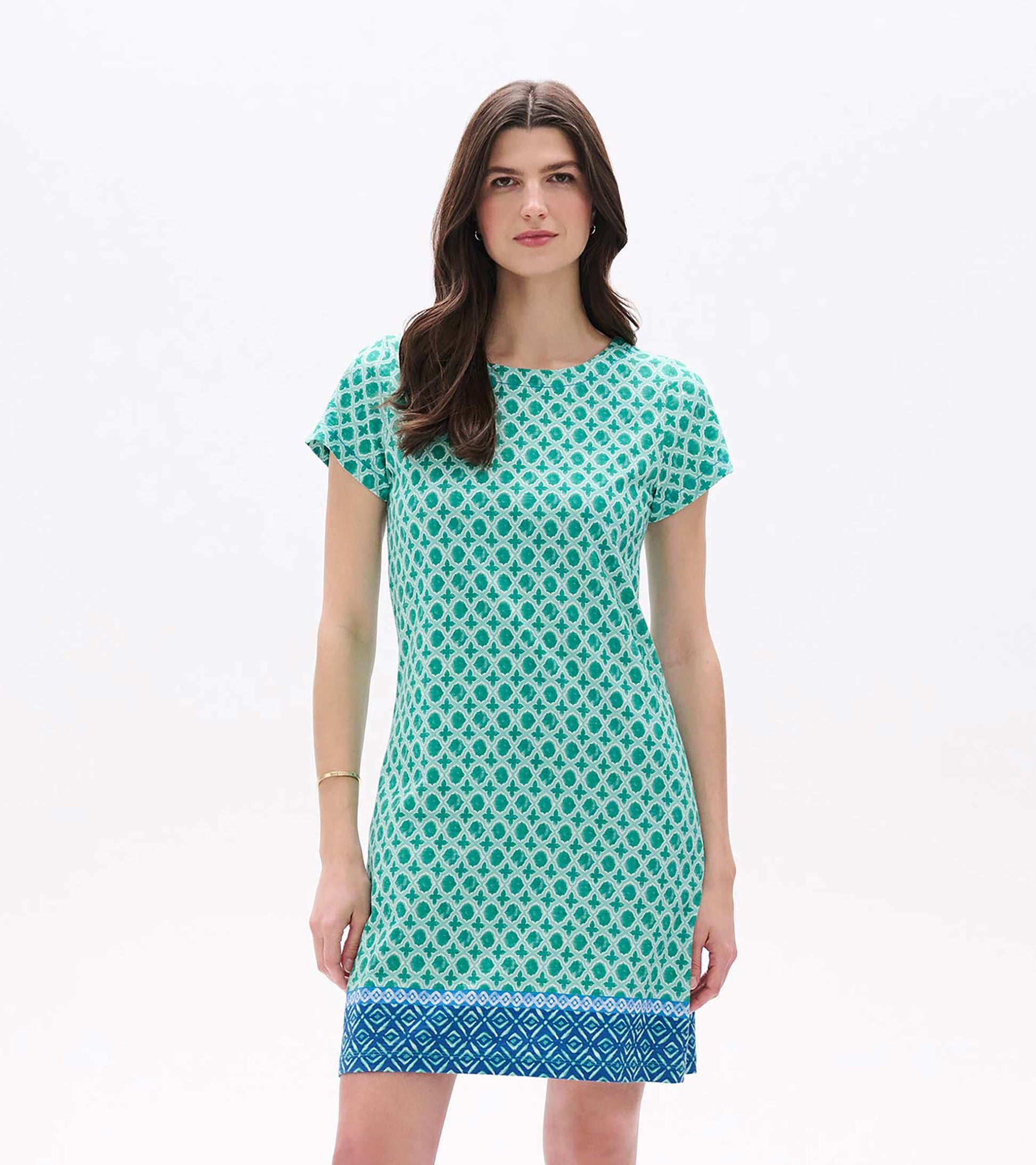 Front view of green printed tee dress with short sleeves and blue patterned border hem