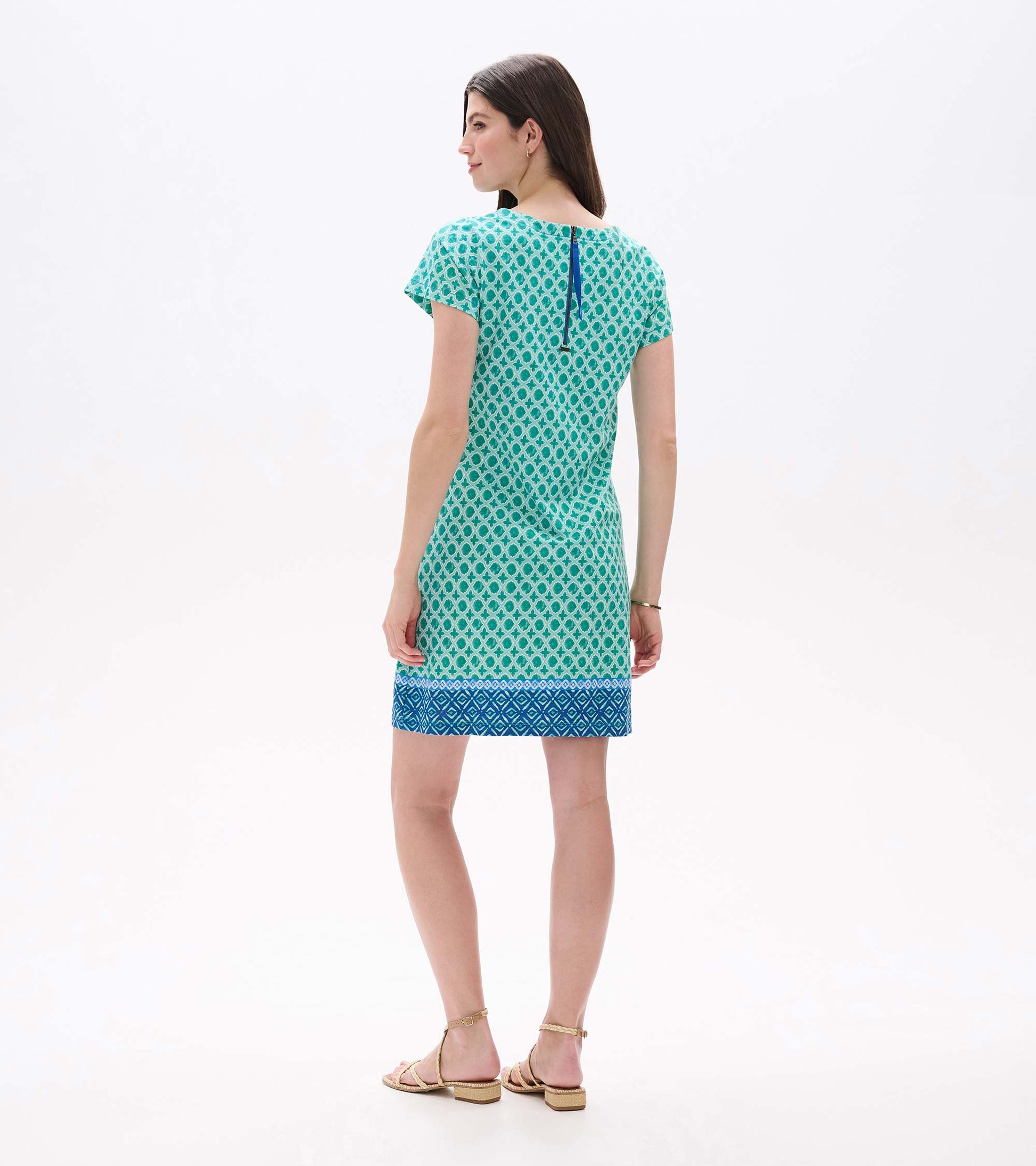 Back view of green printed tee dress with short sleeves, blue border hem, and visible back zipper