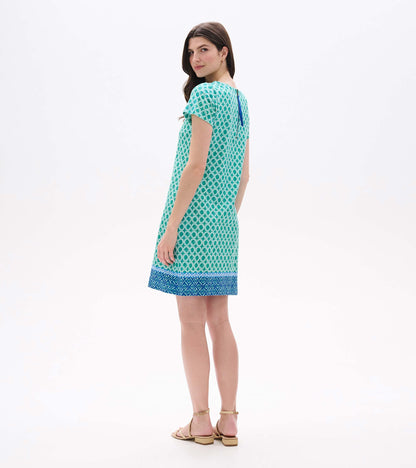 Back angled view of green medallion print tee dress with blue border hem and exposed back zipper