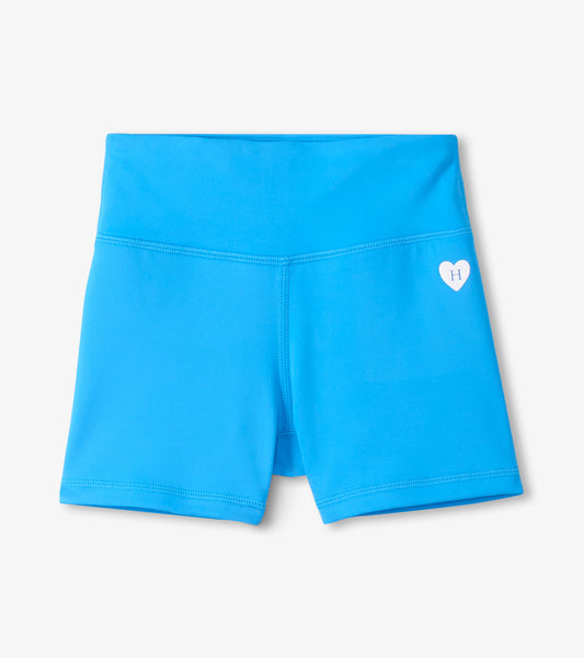 Bright blue girls’ active shorts with a white heart logo, front view
