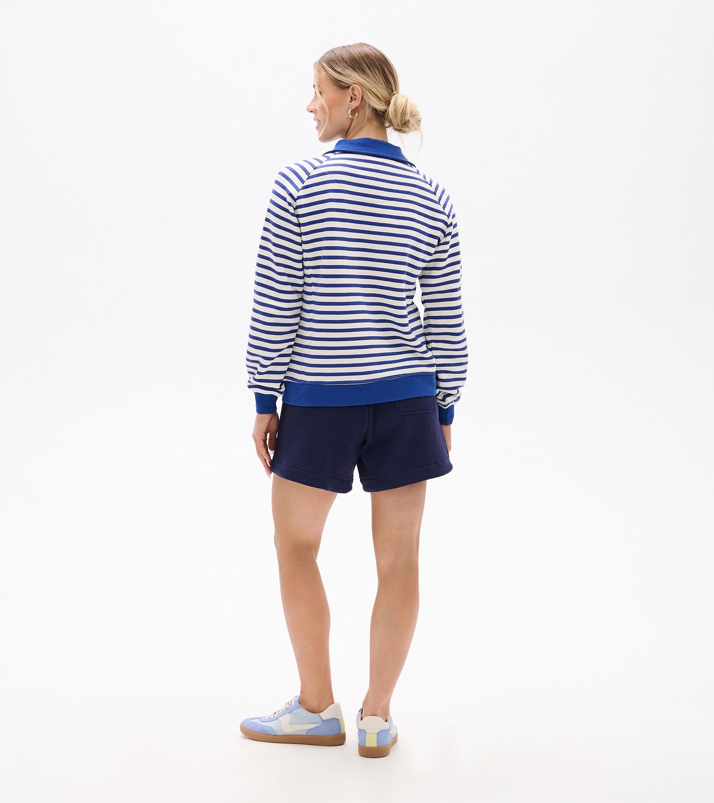 Back view of blue and white striped mock neck pullover with blue collar, cuffs, and hem