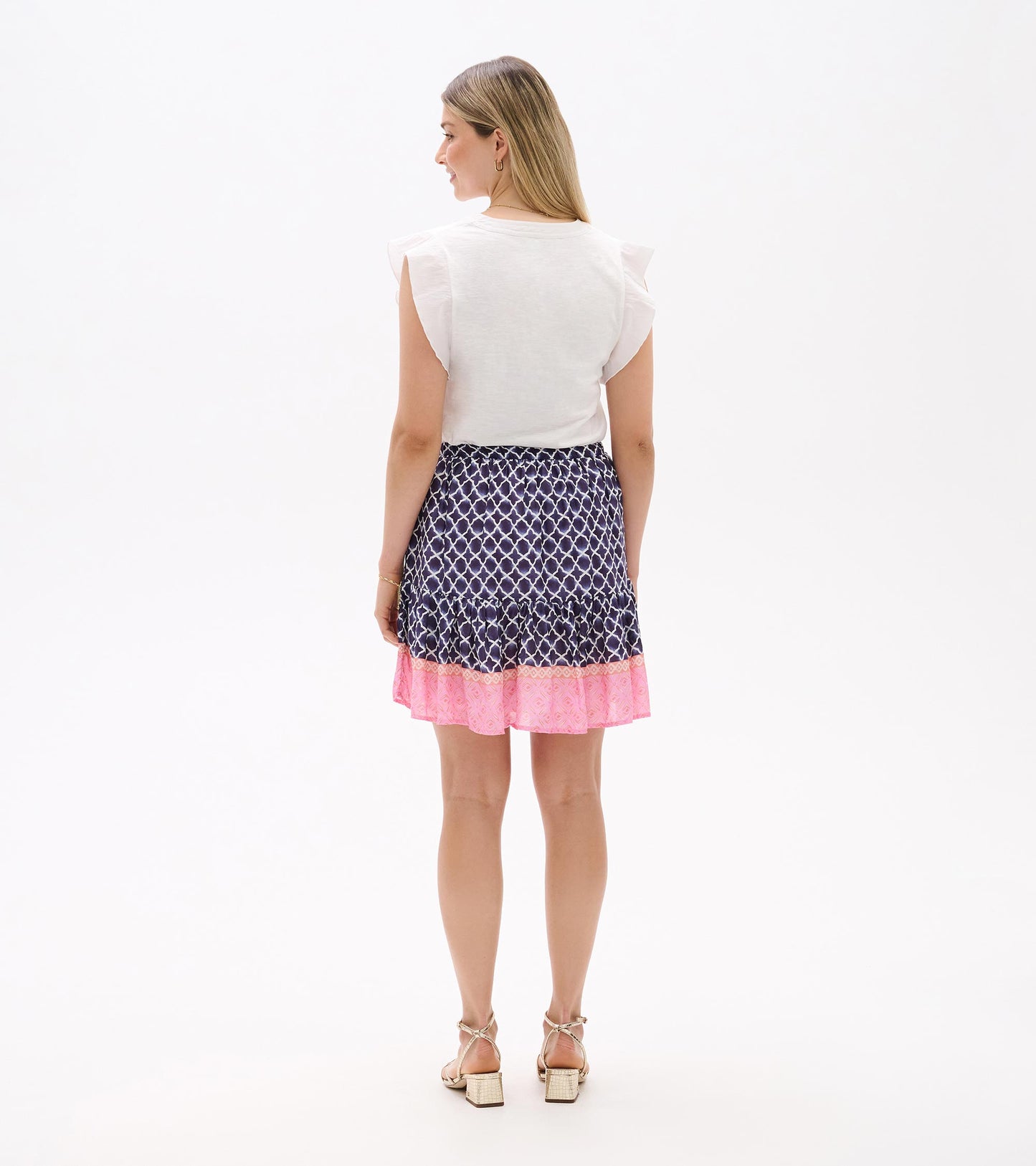 Back view of a navy medallion print tiered flounce skirt with pink hem and elastic waist