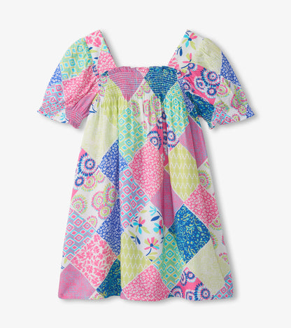 Back view of girls patchwork smocked dress with puff sleeves in pink, blue, white, and green