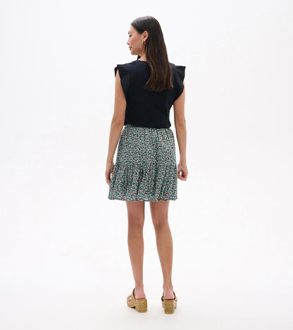 Back view of a black sleeveless top with a teal and white floral mini skirt and pleated hem