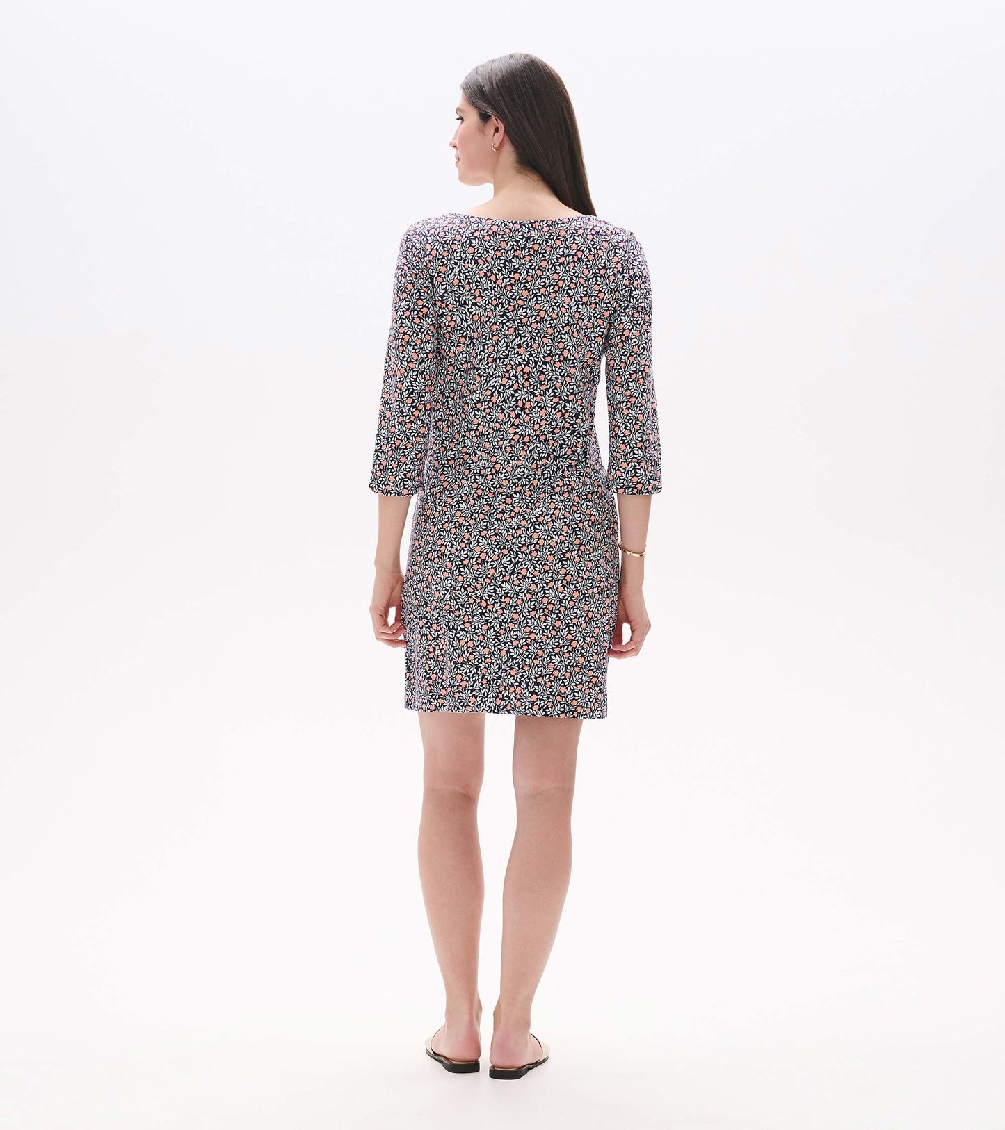Back view of a navy mini dress with pink floral vine print, notch neck, and three-quarter sleeves