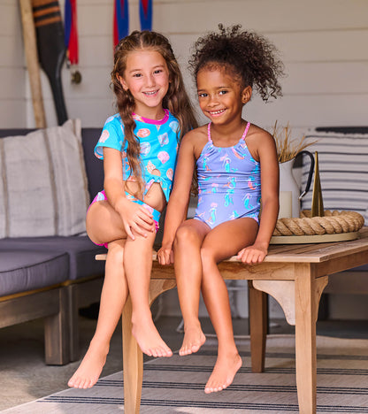 Girls two-piece swimsuits with sea shell and seahorse prints, one blue tie-front set and one purple halter set, front view