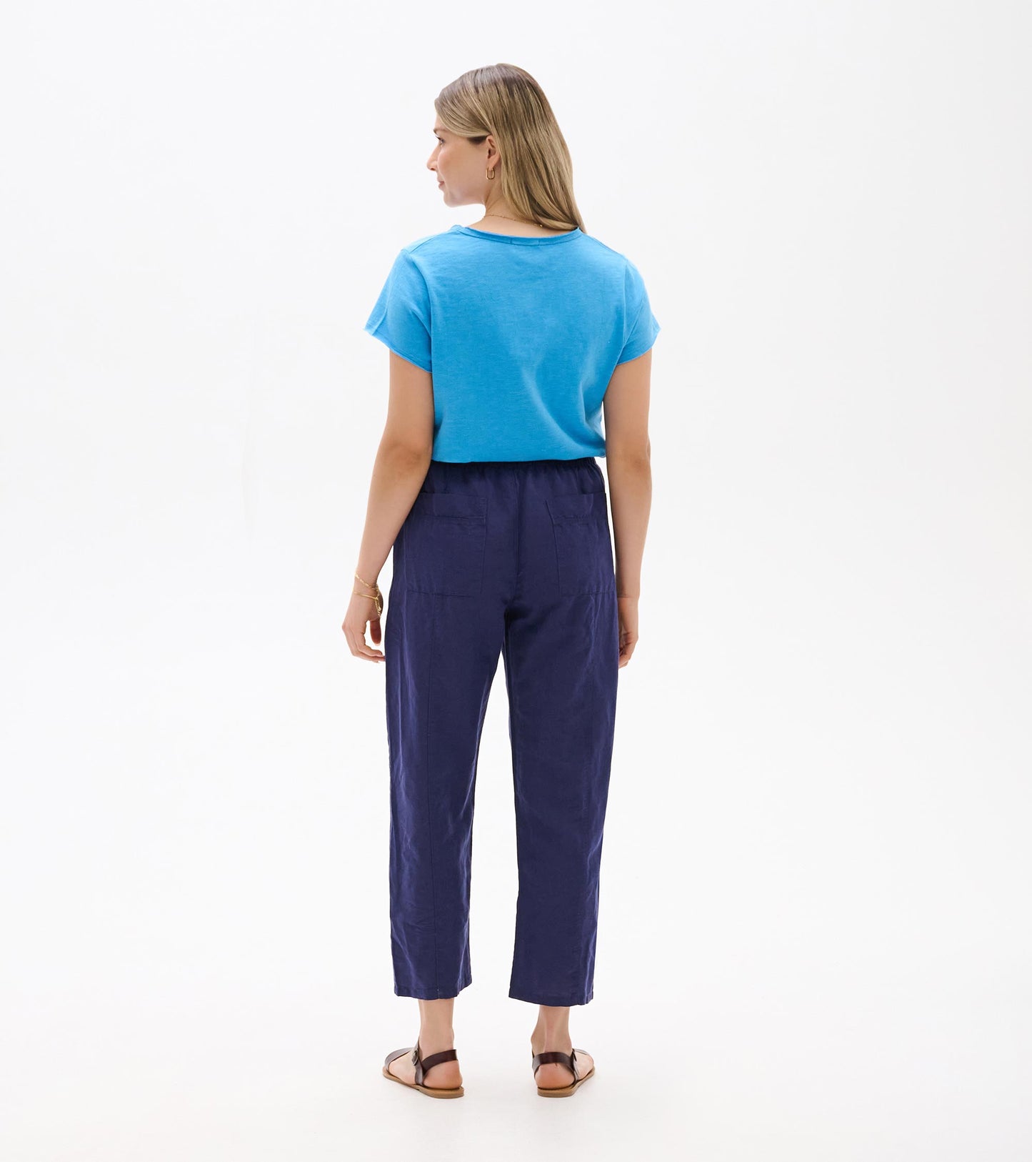 Back view of navy straight-leg pants with cropped ankle length and elastic waistband