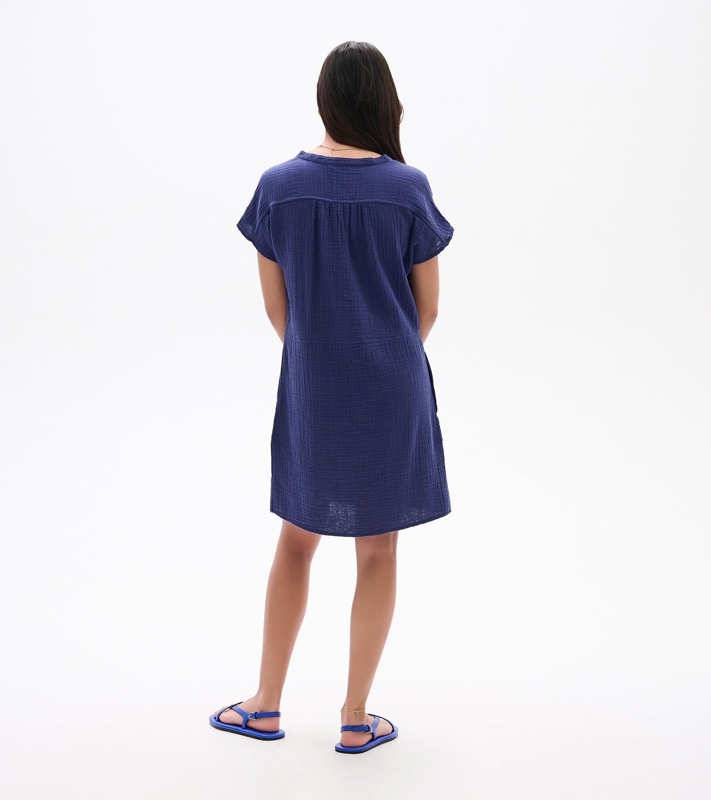 Back view of a navy blue short-sleeve knee-length dress with a relaxed fit and textured fabric