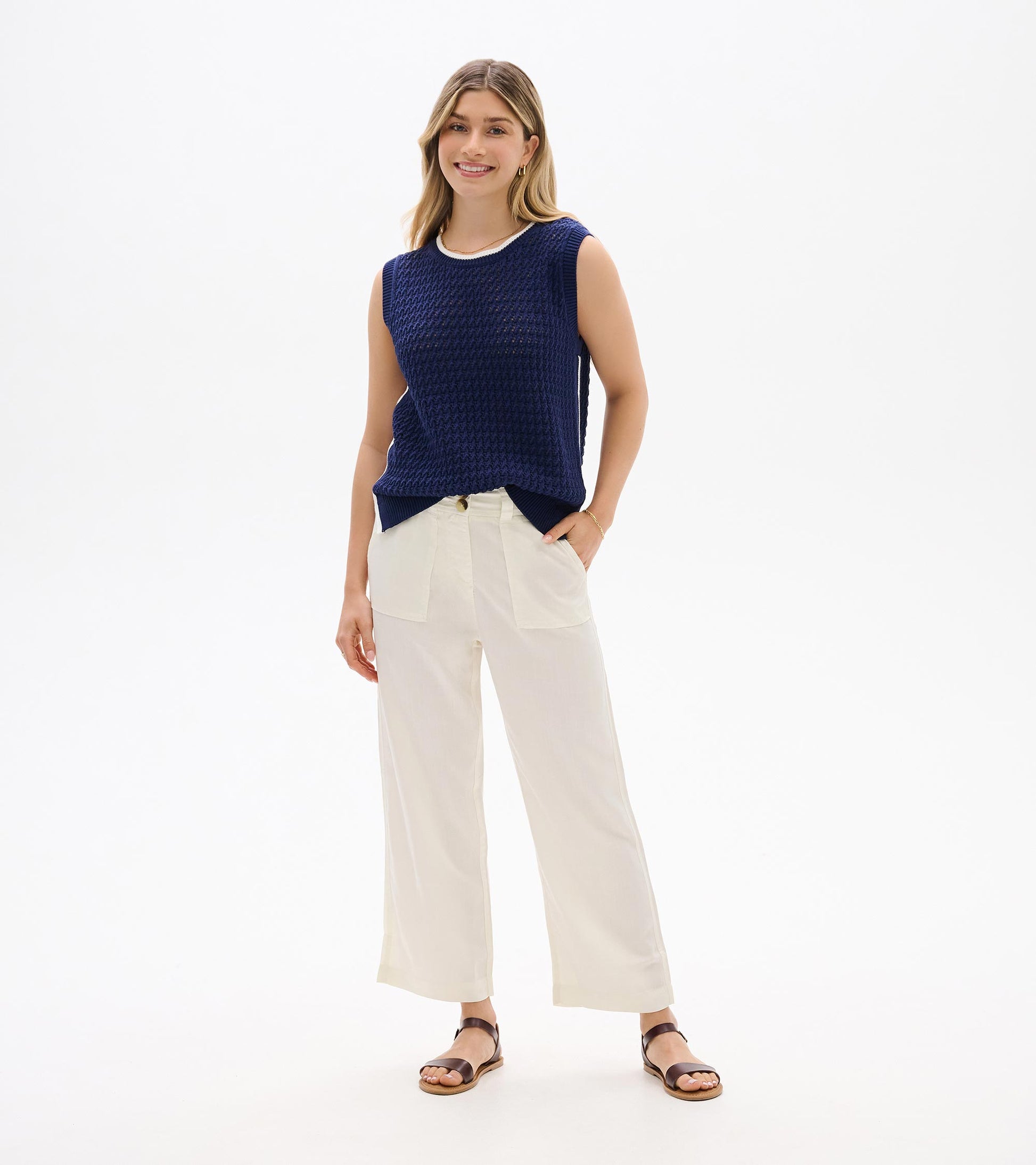 Navy blue sleeveless knit tank top with crew neck, shown on a model front view.