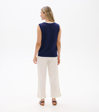 Back view of a navy blue knit sleeveless tank top with ribbed trim and textured pattern