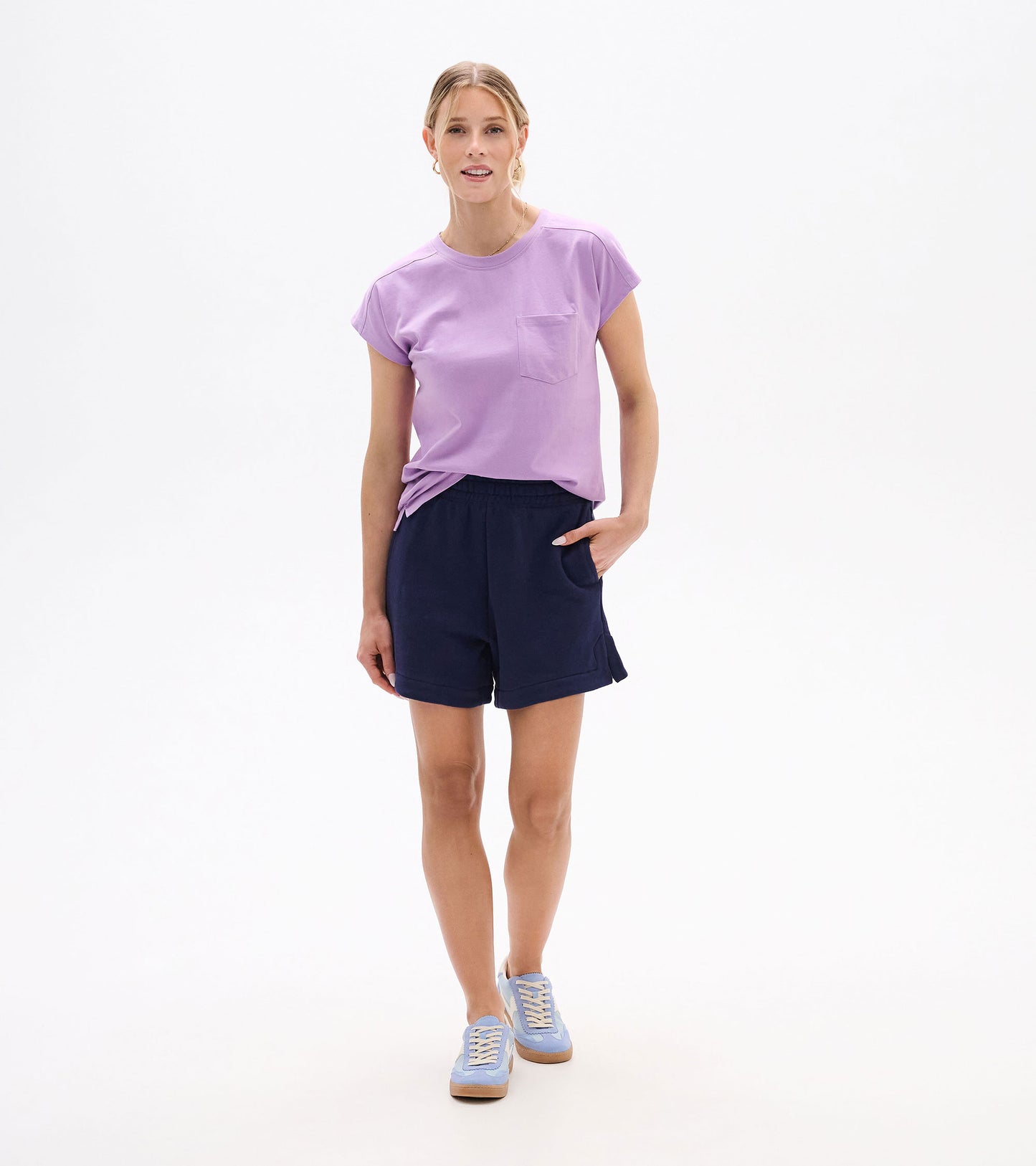 Woman wearing navy pull-on shorts with elastic waist and side pockets, front view