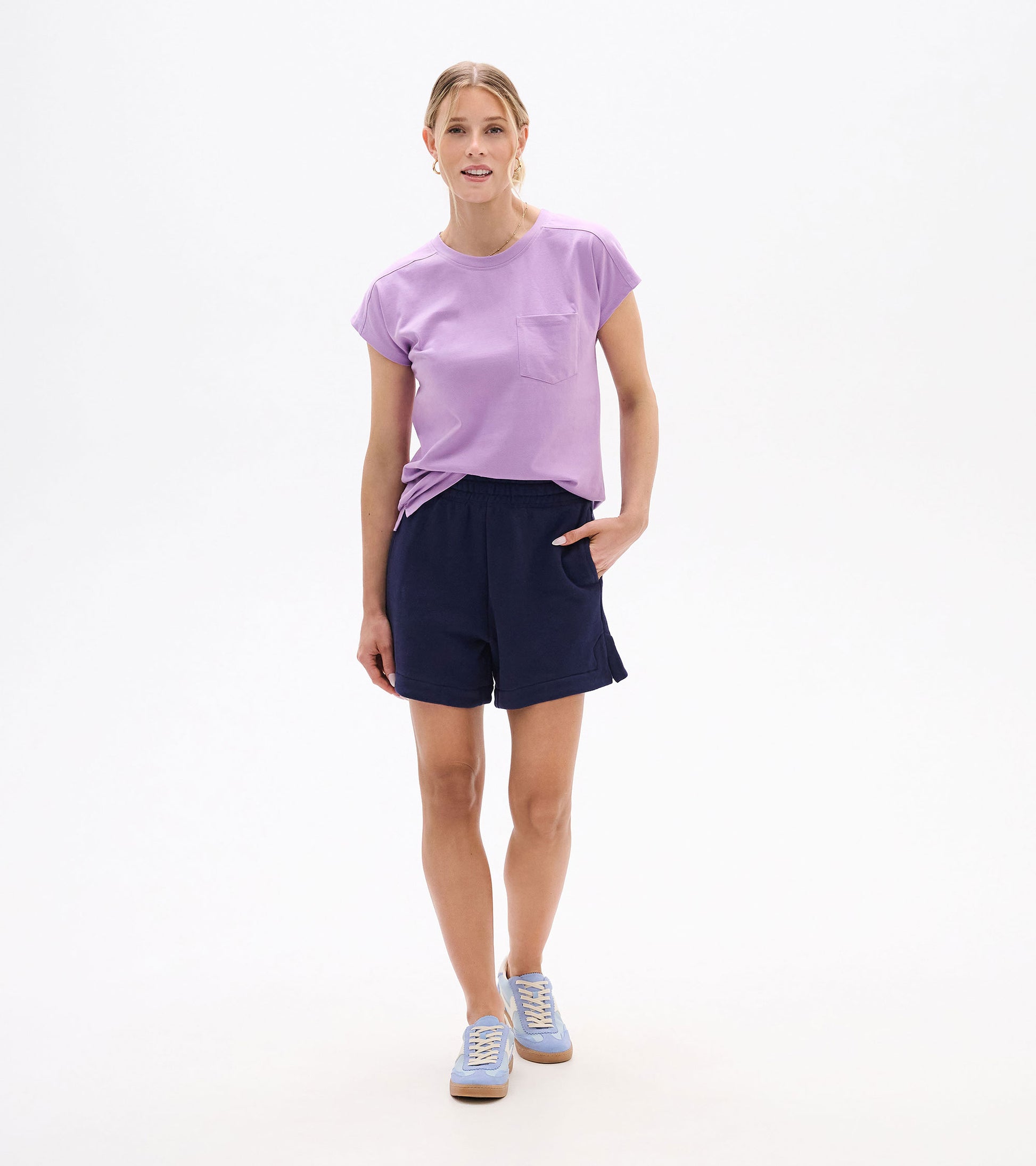 Woman wearing navy pull-on shorts with elastic waist and side pockets, front view