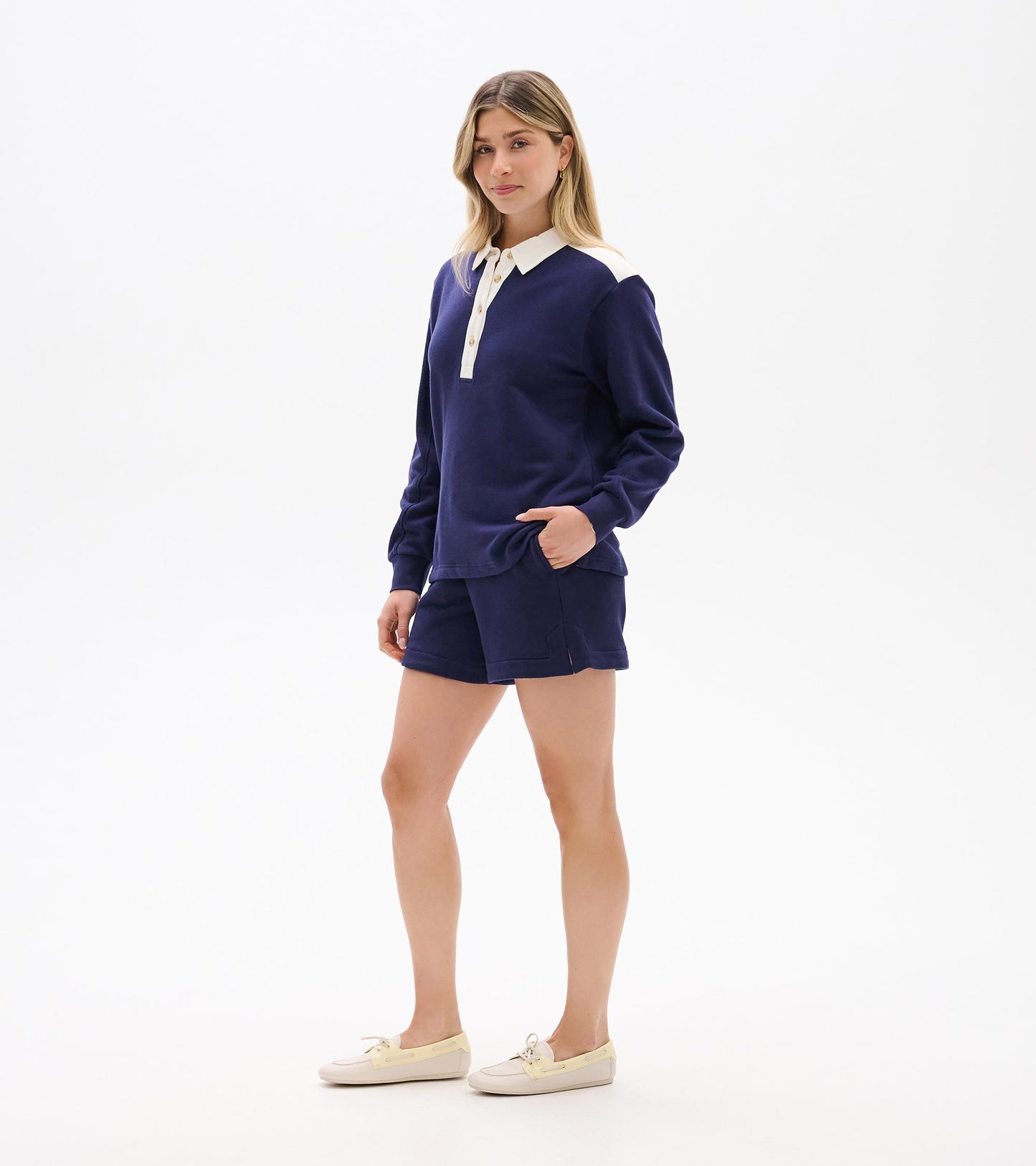 Woman wearing navy long-sleeve polo top with white collar and button placket, front view