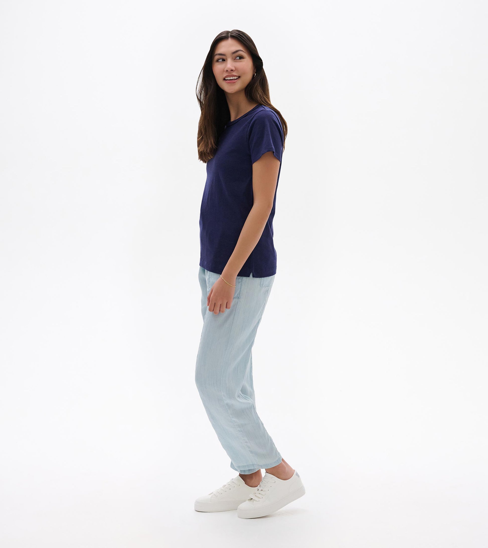 Navy blue short-sleeve crew neck tee with a relaxed fit, shown on a model in side view.